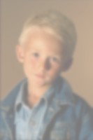 photograph of a boy that is blurred and very light, making it difficult to see details