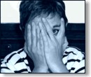 a woman hides behind her hands